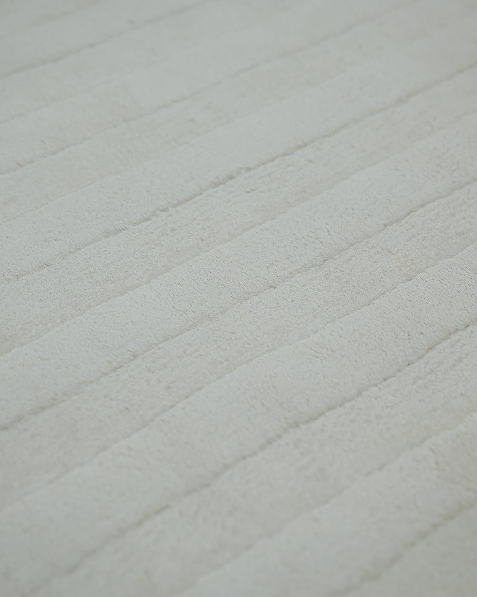 Ivory white carved Meander high-low bamboo silk rug texture close-up
